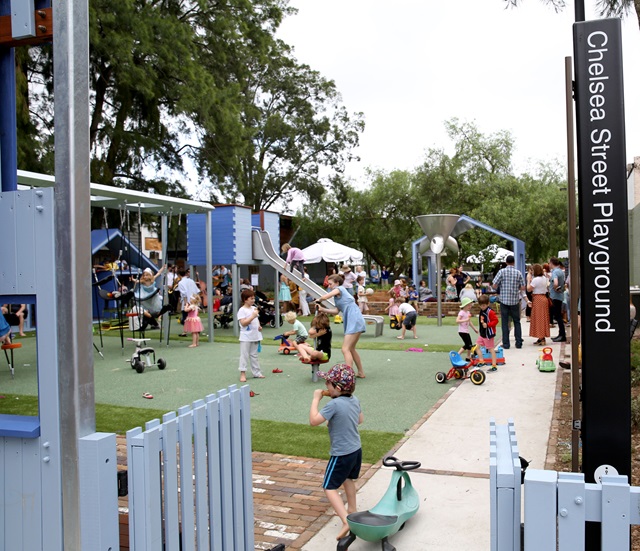 A view from the fence of the playground filled with children playing
