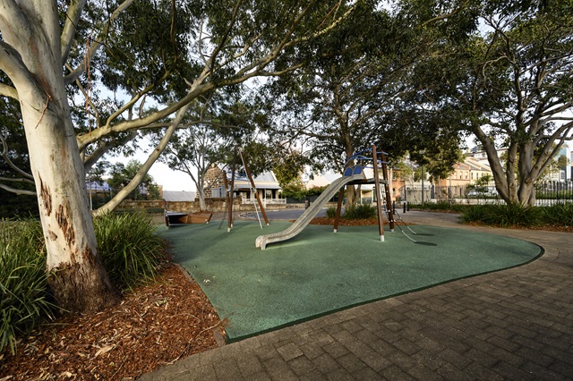 Playground equipment in a park and trees around it.