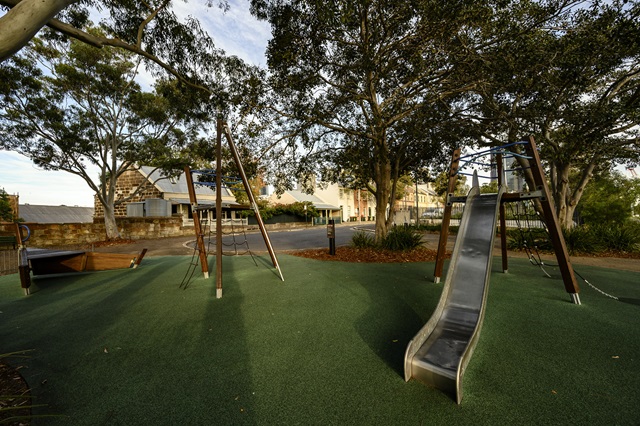 Playground equipment in a park and trees around it.