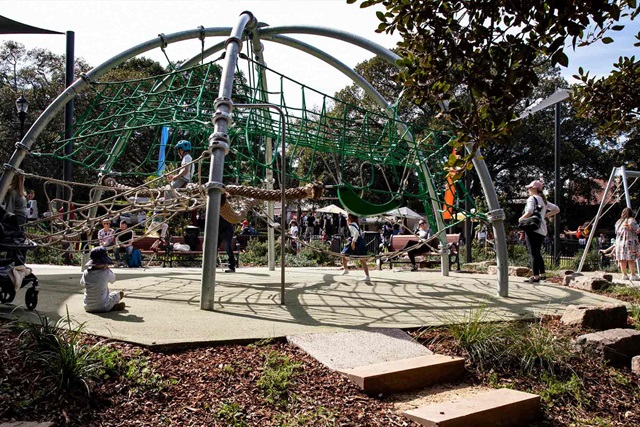 Children playing on a large climbing frame at the centre of the playground