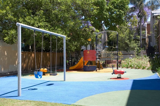 View of the play equipment including slide and fort at May Pitt Playground.