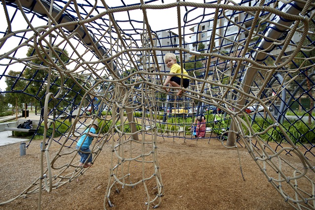 3 children playing on rope climbing structure at Pirrama Park Playground.