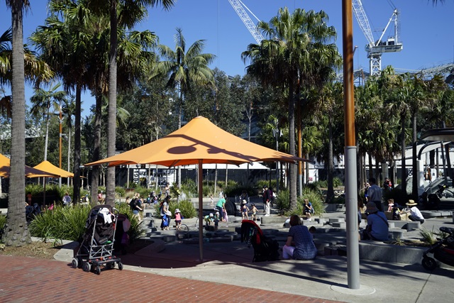 View of families at play under shaded seating at Tumbalong Park