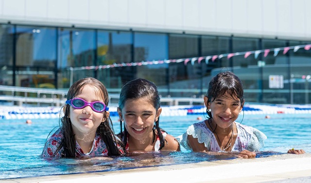 3 girls enjoy the swimming pool.