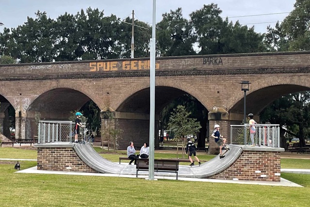 Children playing on an outdoor halfpipe skate ramp