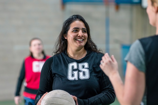 A smiling person holding a ball