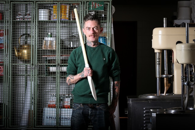 A man standing in front of a locker filled with equipment.