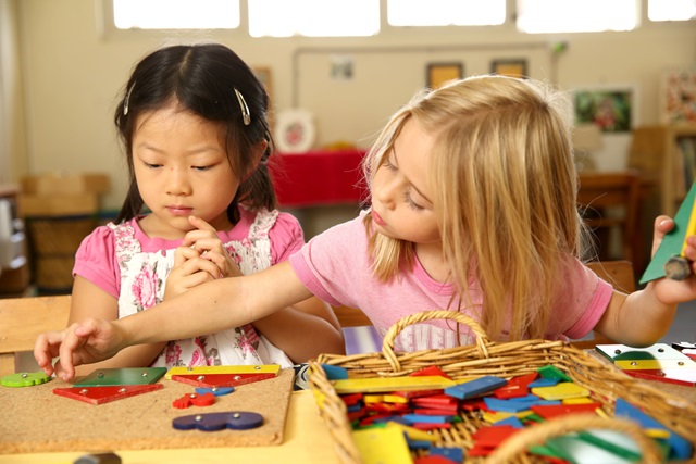 Two young children playing with colourful toys