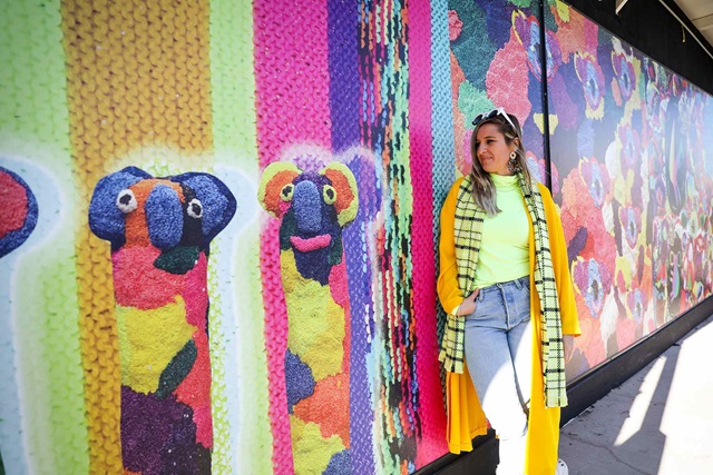 Artist Rosie Deacon standing alongside her creative hoarding design