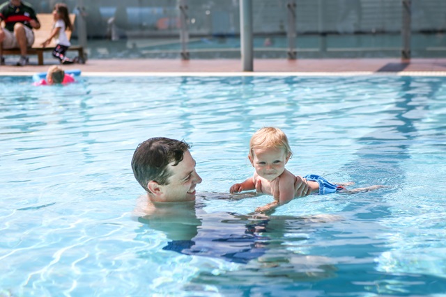 Adult and small child in pool
