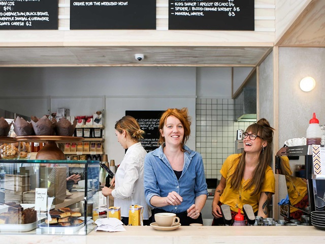 3 women working behind a counter in a cafe