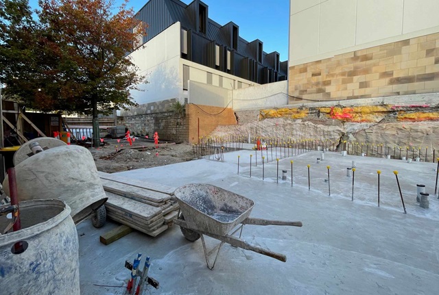 A semi complete concrete slab on a building site surrounded by building equipment.