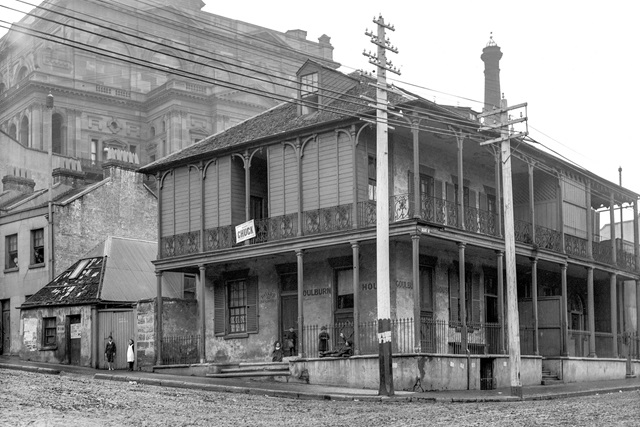 Corner of Druitt and Kent streets in 1901: a 2-storey building with a painted sign reading "Goulburn House Board & Residence" with children sitting on the porch.