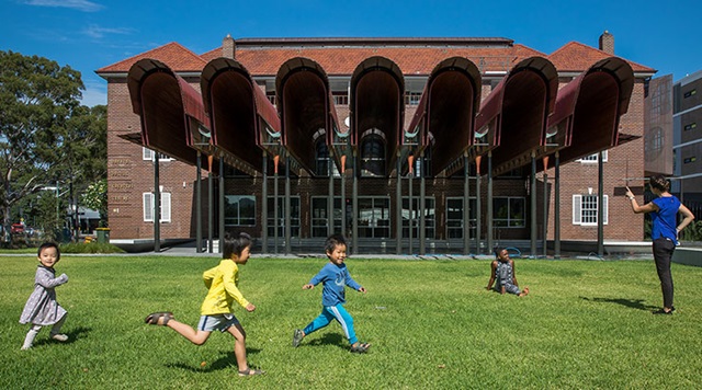 Children running on the front lawn of the Joynton Avenue Creative Centre