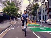 A woman riding a bicycle on a cycleway.