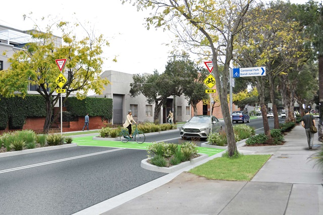 A photomontage of the proposed cycleway showing two people riding, a car giving way to a rider and people walking.