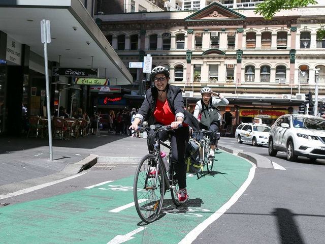 Two women on bicycles ride the Kent Street cycleway.
