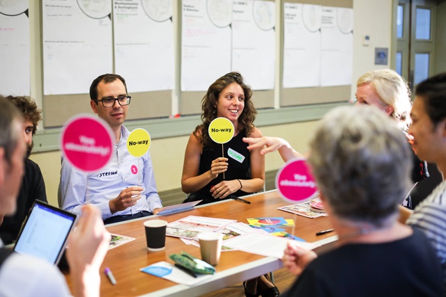 People are seated around a table at a workshop.
