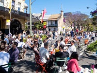 Groups of people enjoy outdoor dining and socialising on suburban streets