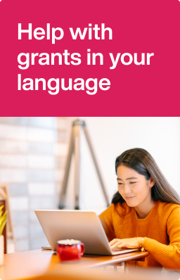 Young woman sitting at a desk typing on a laptop.