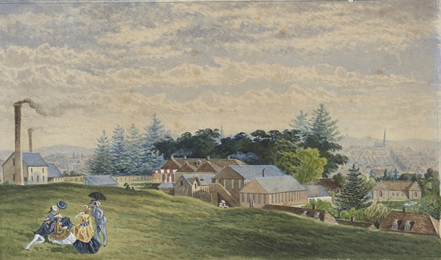 An historic image of people sitting in a park and buildings in the distance.
