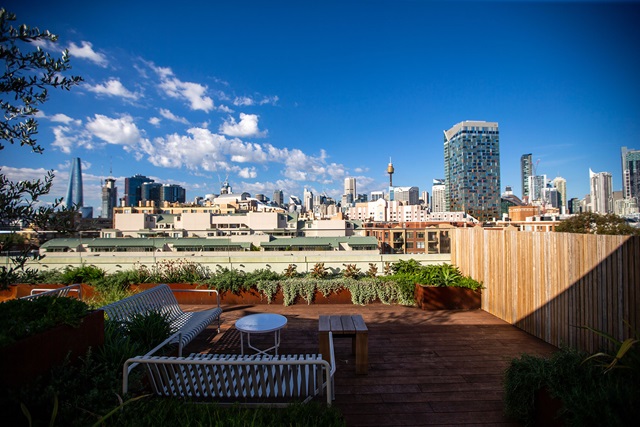 Seating and tables on a rooftop terrace with the city skyline in the background