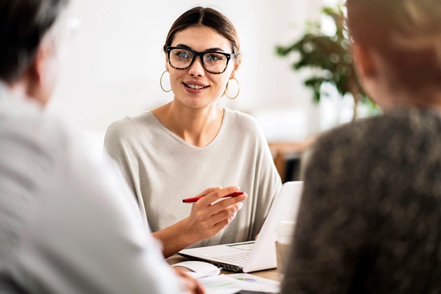 3 people having a meeting around a desk