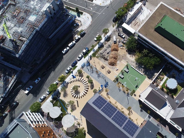 Aerial view of a street with a building covered in scaffolding and construction works in progress.