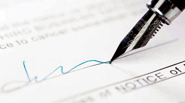 A calligraphy pen used to sign a piece of paper.