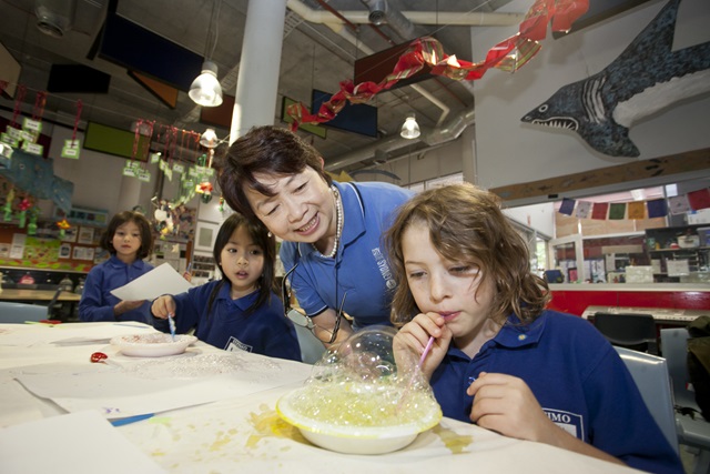 A teacher or parent with a small child at a table