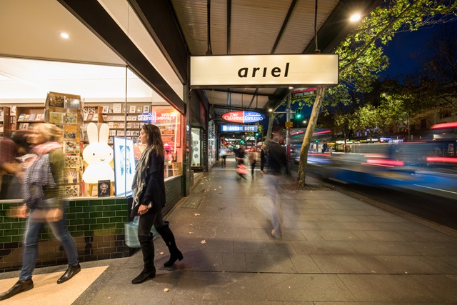 People on the sidewalk in a city at night