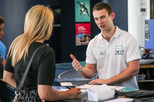 Female customer talking to a staff member at a reception desk