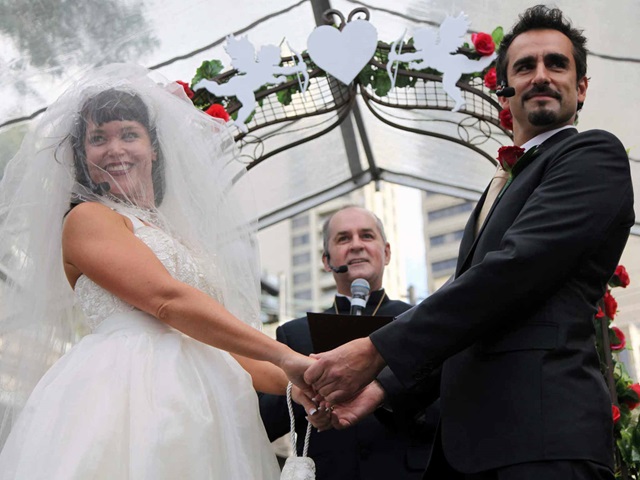 A bride and groom hold hands during a wedding ceremony