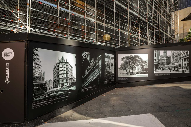 Historic photographs applied to boards at the base of a building.