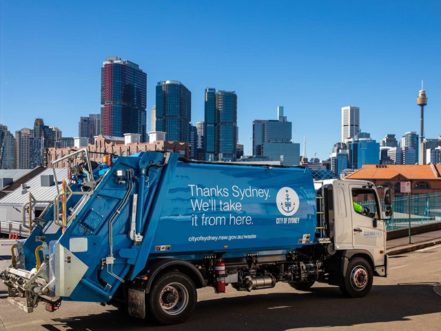 A garbage truck and a city skyline.