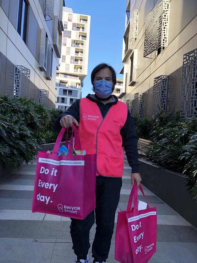 A RecycleSmart driver collecting bags from an apartment building